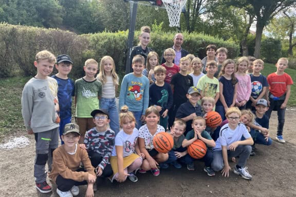 Foto mit einigen Kindern und Erziehern von der Übergabe des Basketballkorbes an den Hort Glück-Auf in Zauckerode. Foto: WGF