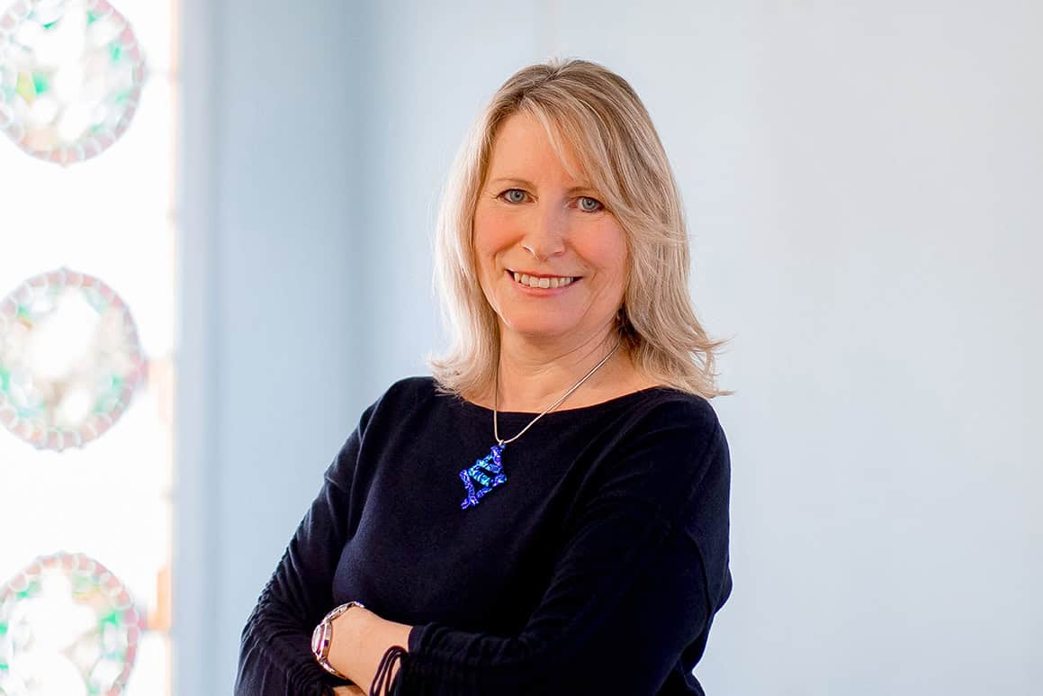 Porträtfoto von der lächelnden Andrea Kaiser, Mietenbuchhalterin im Team Rechnungswesen der Wohnungsgesellschaft Freital mbH. Foto: Anne Oehlert.