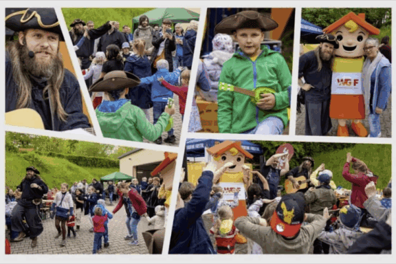 Besucher beim Stadtteilfest Zauckerode 2024 vor der Bühne mit bunten Ständen und fröhlicher Atmosphäre. Foto: W. Papperitz