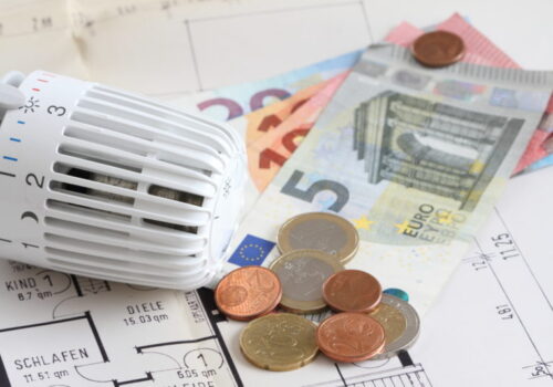 Foto zur Mieterinformation zu Energieträgern, Heizungsthermostat mit Geldscheinen auf einem Bauplan, Foto: Adobe Stock